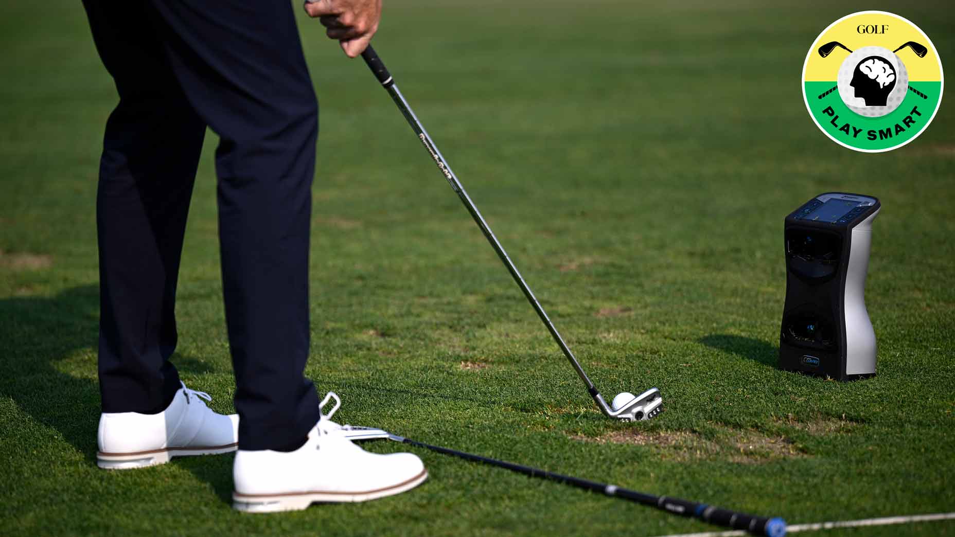 golfer sets up to ball with launch monitor next to them